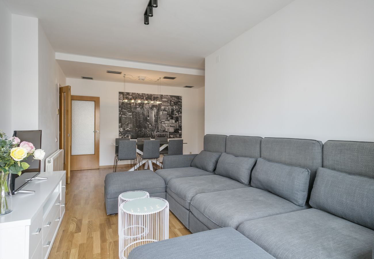 living room with TV, comfortable cauch and dining area in 3-bedroom apartment